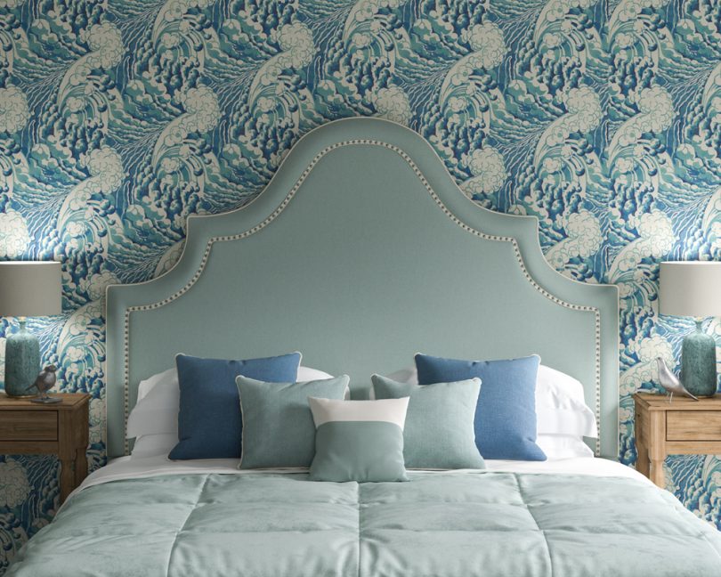 Kerrera Curved Keystone Shape Headboard in House Cotton Peppermint with inset silver nailed ivory braid, against Linwood wave sea wallpaper