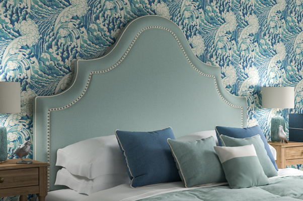 Kerrera Curved Keystone Shape Headboard in House Cotton Peppermint with inset silver nailed ivory braid, against Linwood wave sea wallpaper